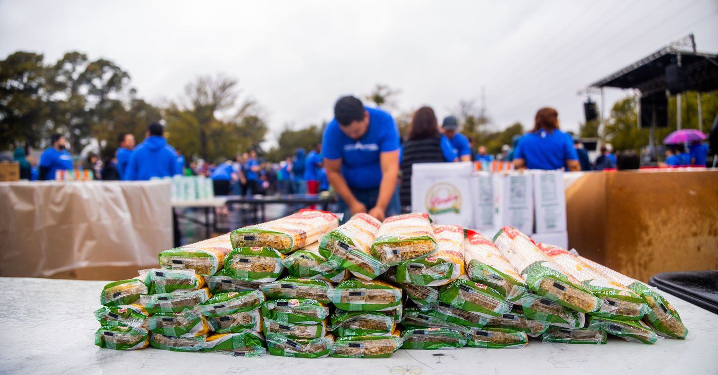 Fotografia ilustrativa de voluntários organizando e distribuindo alimentos para famílias